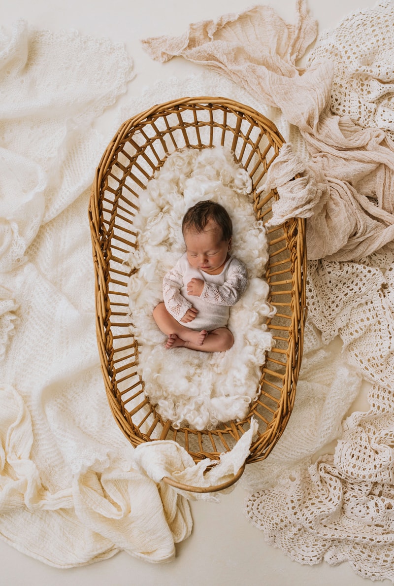 London Family Photographer, little newborn baby cozy in a basket with white linens